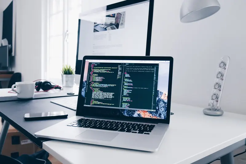 Laptop with code on a web developer’s desk