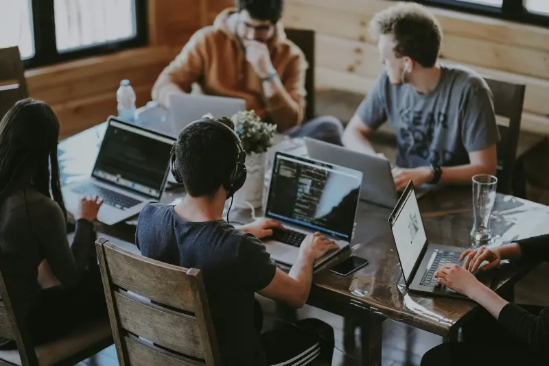 Group of people working together on laptops