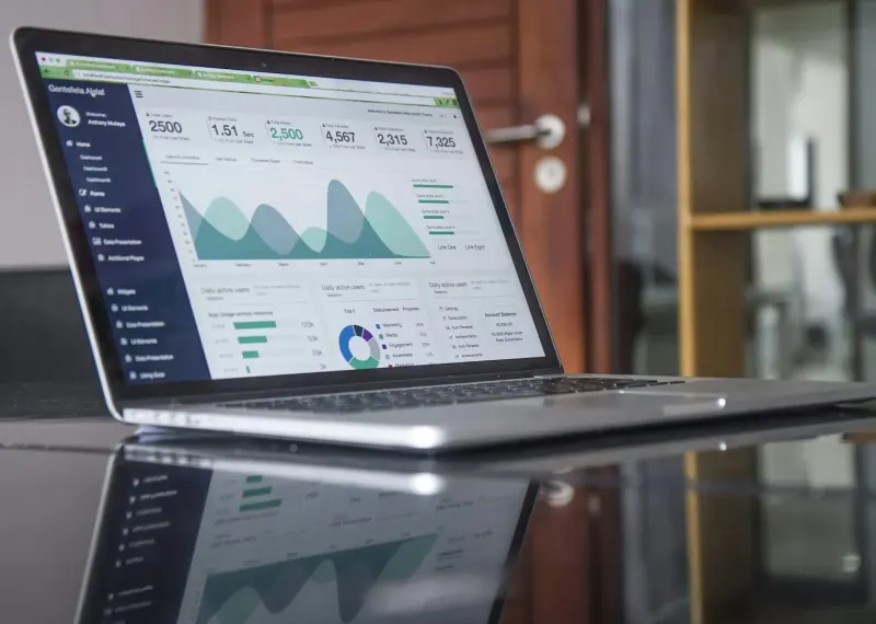Laptop showing analytics charts on a glass table