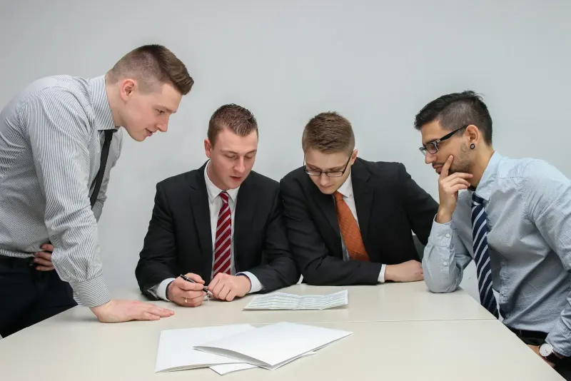 Four people looking at papers on a table